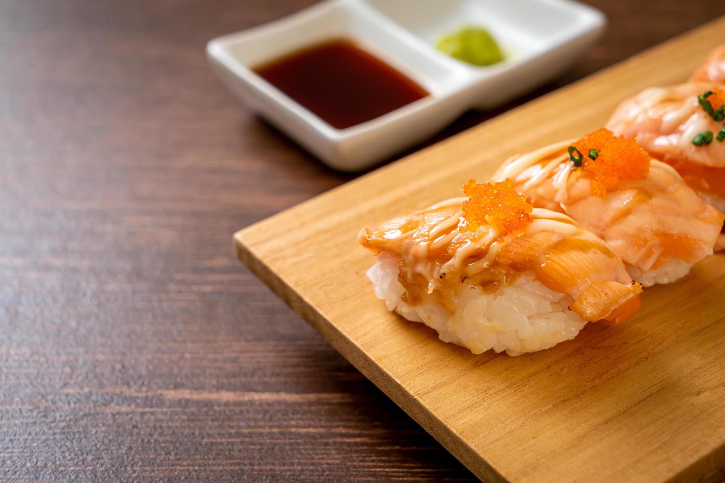 Sushi de salmón a la parrilla en una placa de madera - estilo de comida japonesa foto