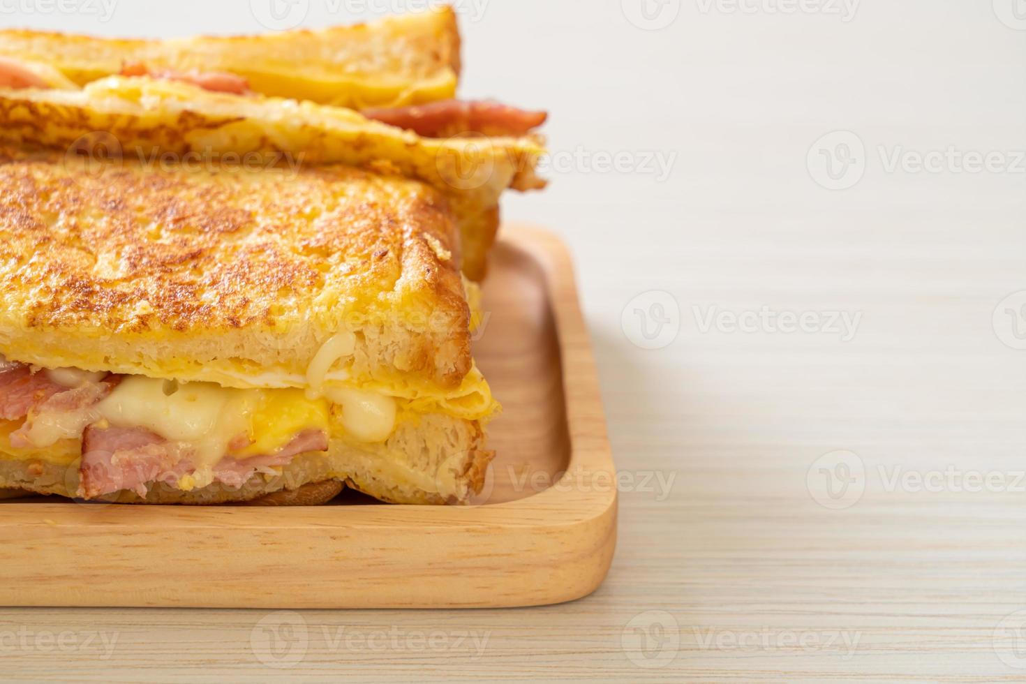 tostada francesa casera con sándwich de jamón, tocino y queso con huevo foto