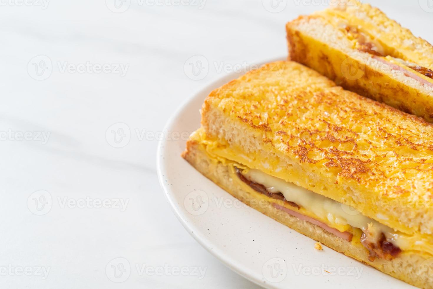 tostada francesa casera con sándwich de jamón, tocino y queso con huevo foto