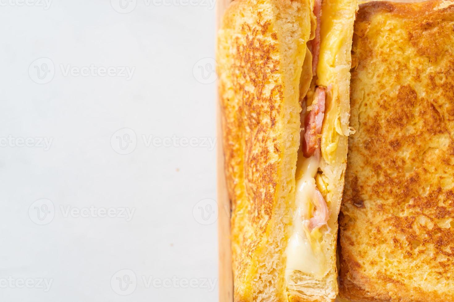 tostada francesa casera con sándwich de jamón, tocino y queso con huevo foto