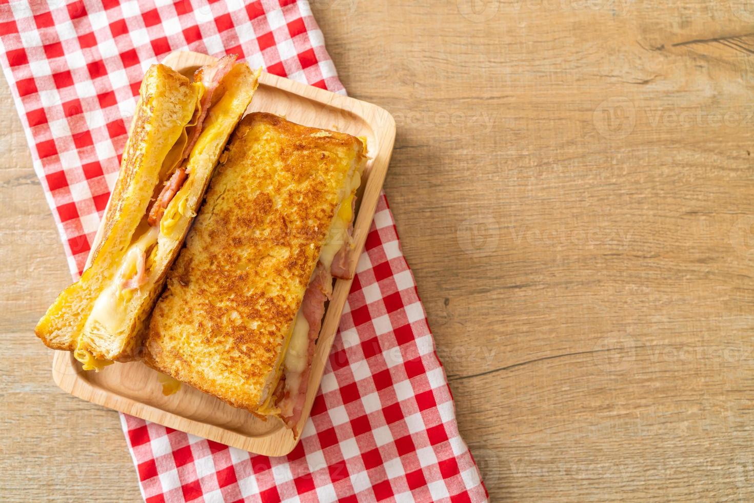 tostada francesa casera con sándwich de jamón, tocino y queso con huevo foto