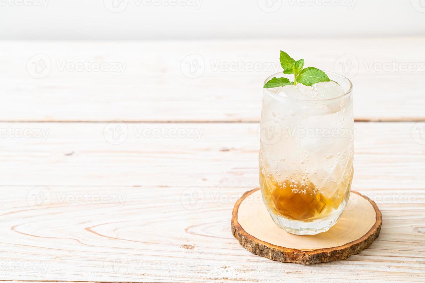 Iced plum juice with soda and peppermint on the wood table - refreshment drink photo