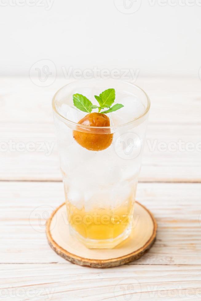 Iced plum juice with soda and peppermint on the wood table - refreshment drink photo