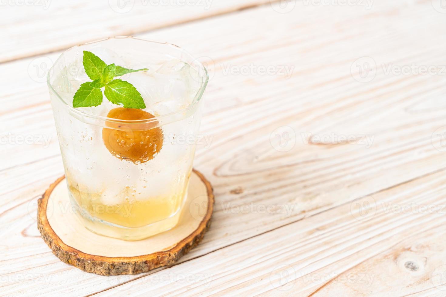 Iced plum juice with soda and peppermint on the wood table - refreshment drink photo