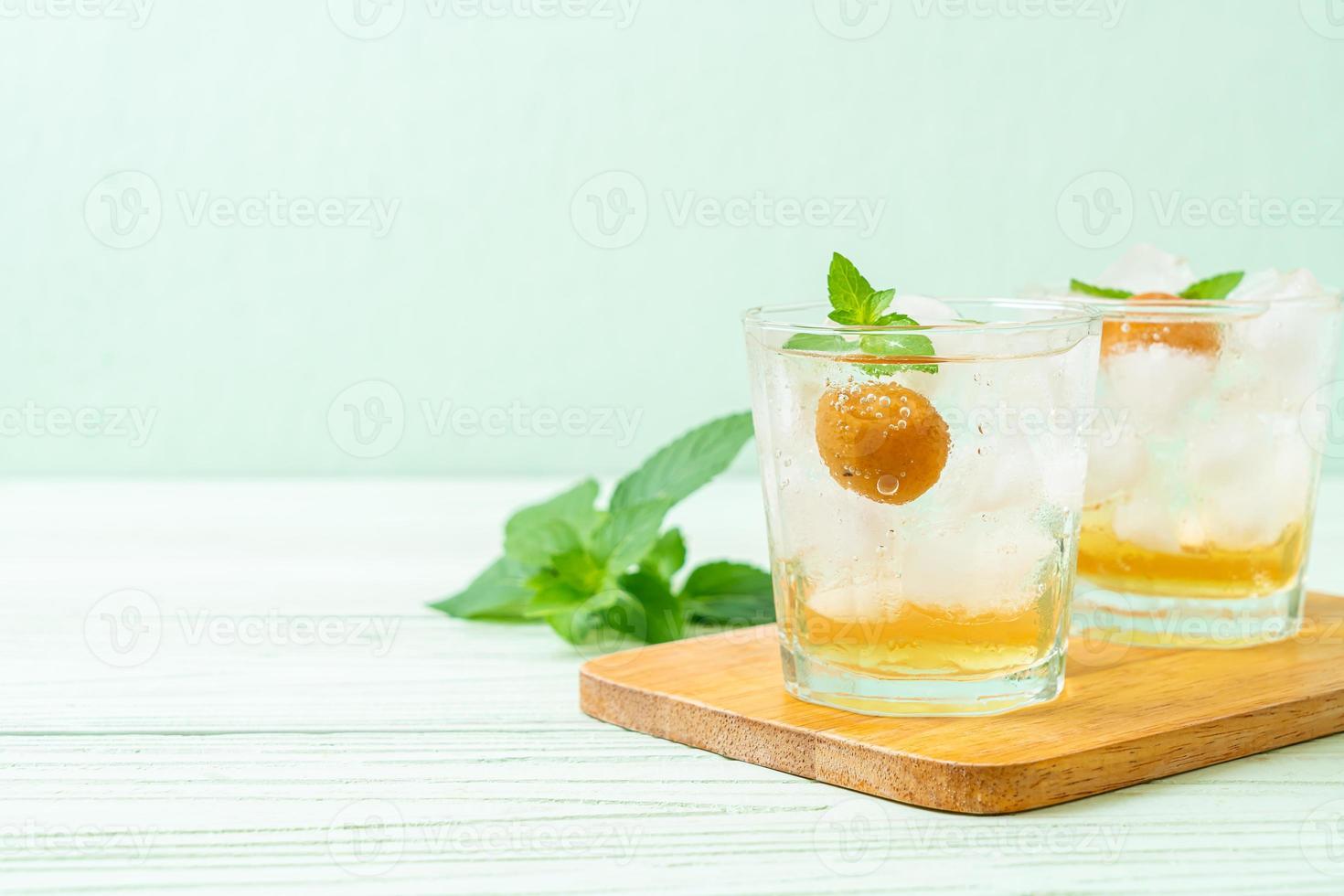 Iced plum juice with soda and peppermint on the wood table - refreshment drink photo
