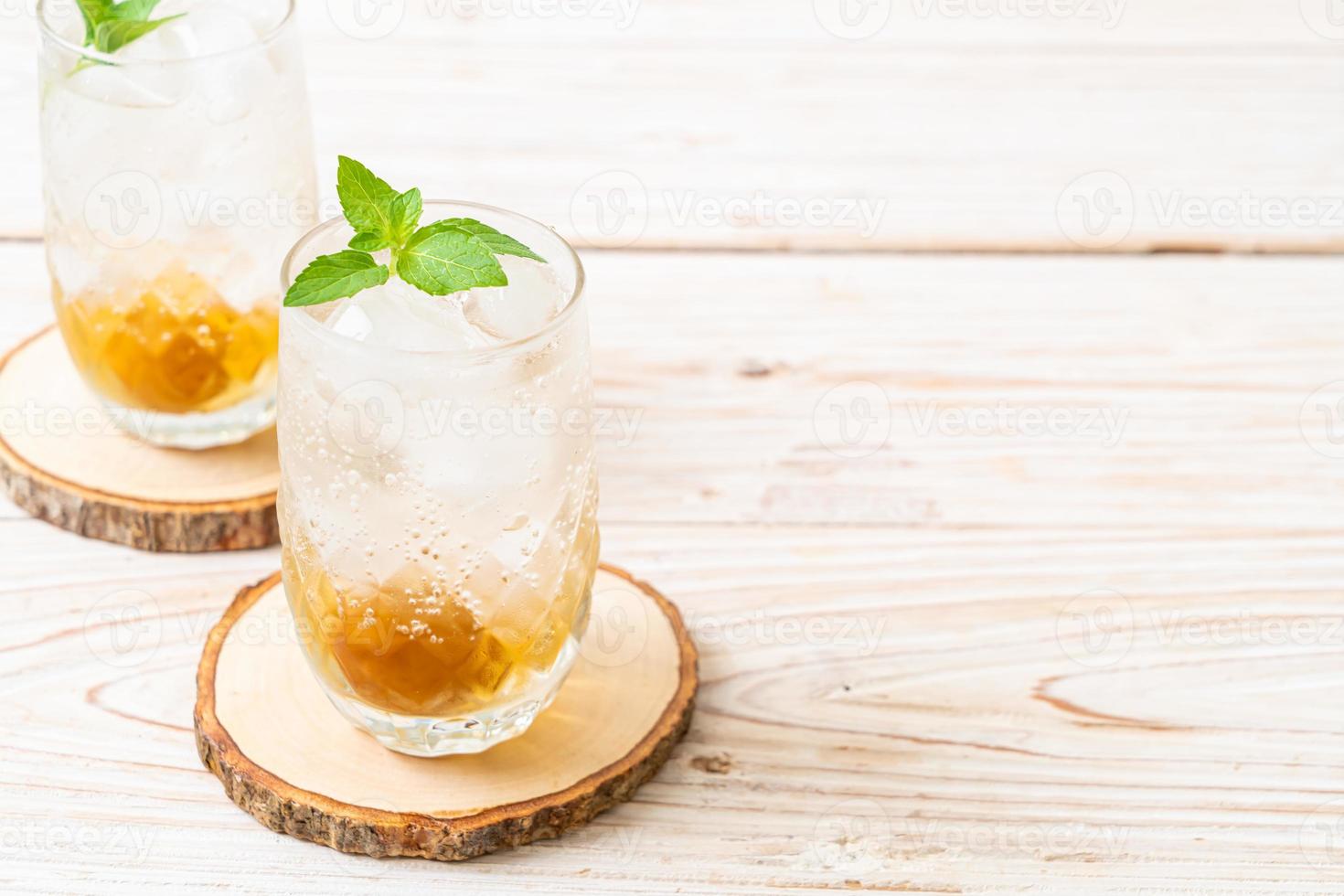 Jugo de ciruela helado con soda y menta en la mesa de madera - bebida refrescante foto