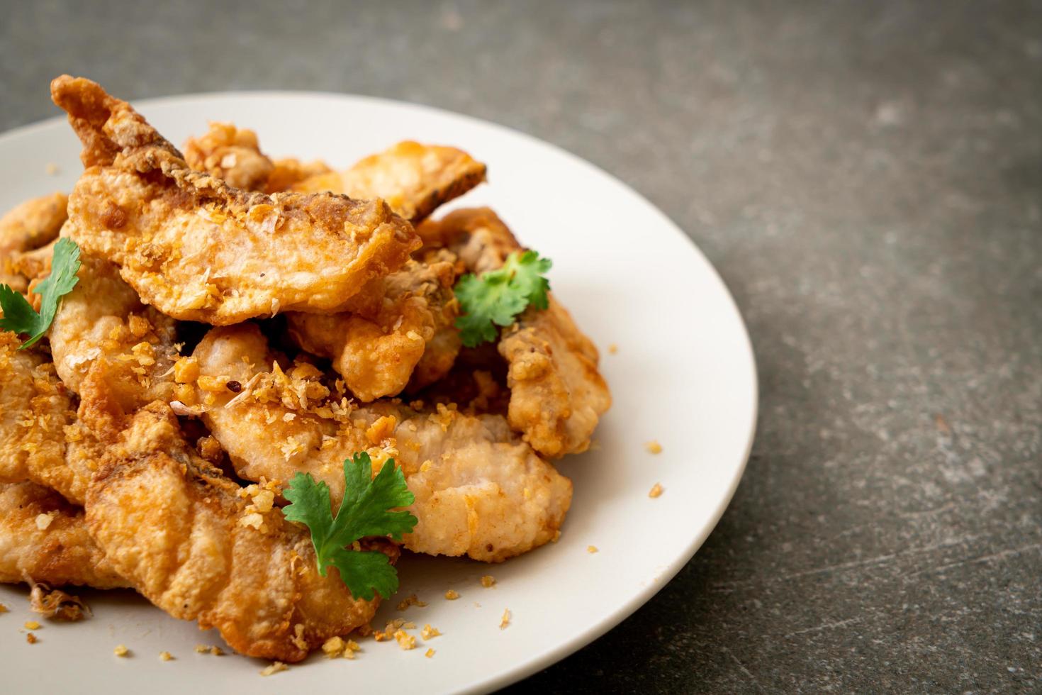 Fried fish with garlic on plate photo