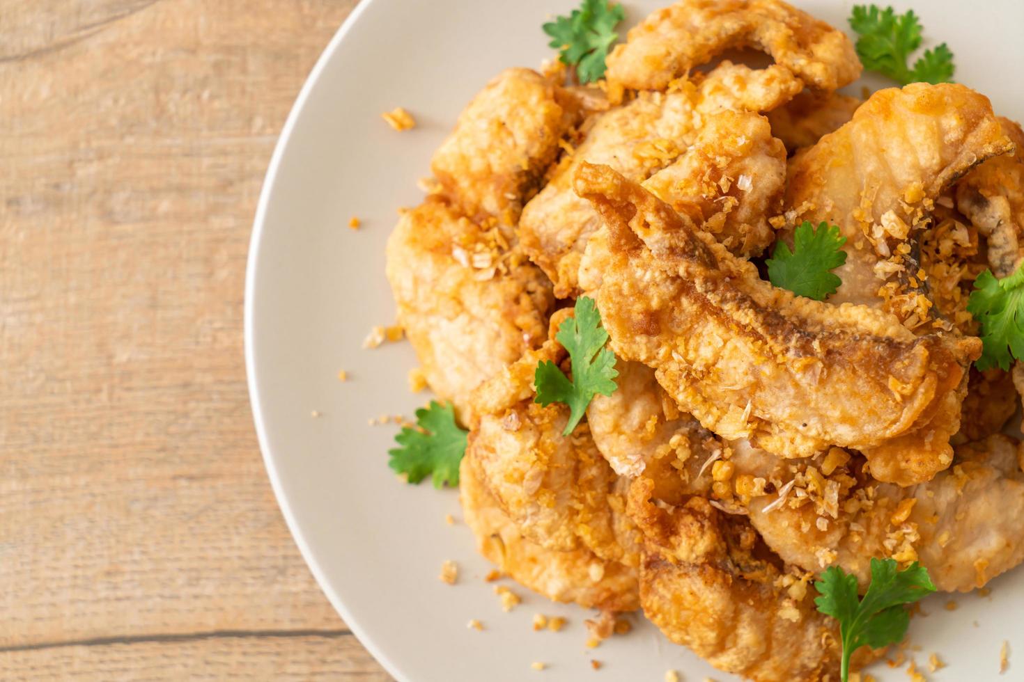 Fried fish with garlic on plate photo