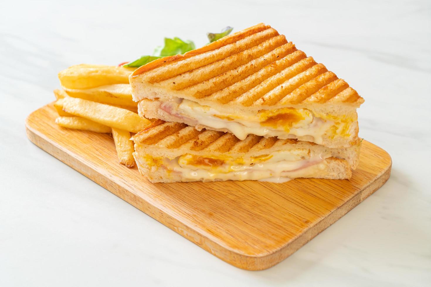 Ham and cheese sandwich with egg and fries photo