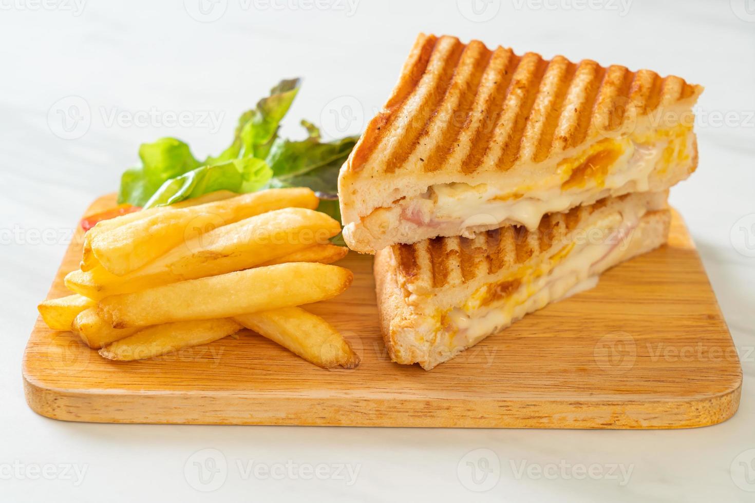sándwich de jamón y queso con huevo y patatas fritas foto