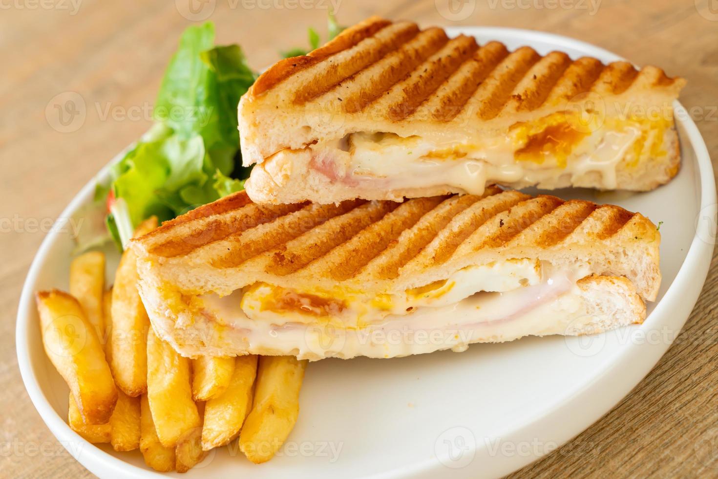 Ham and cheese sandwich with egg and fries photo