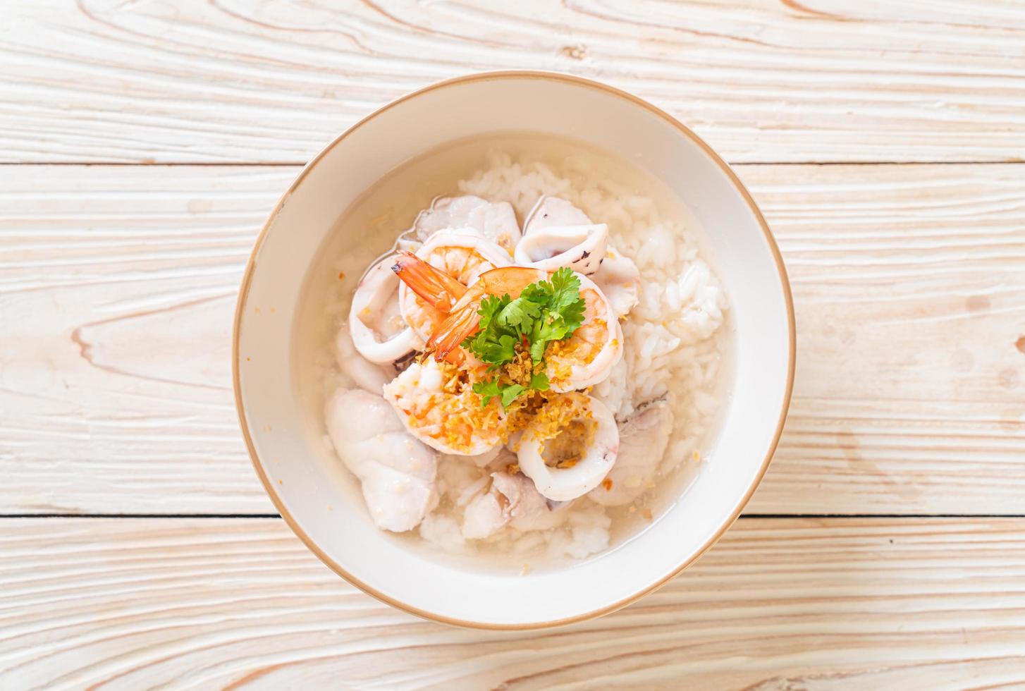 sopa de avena o arroz hervido con mariscos de camarones, calamares y pescado en un bol foto