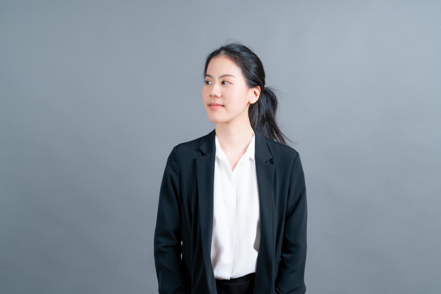 Happy Asian woman with happy face in office clothes on grey background photo