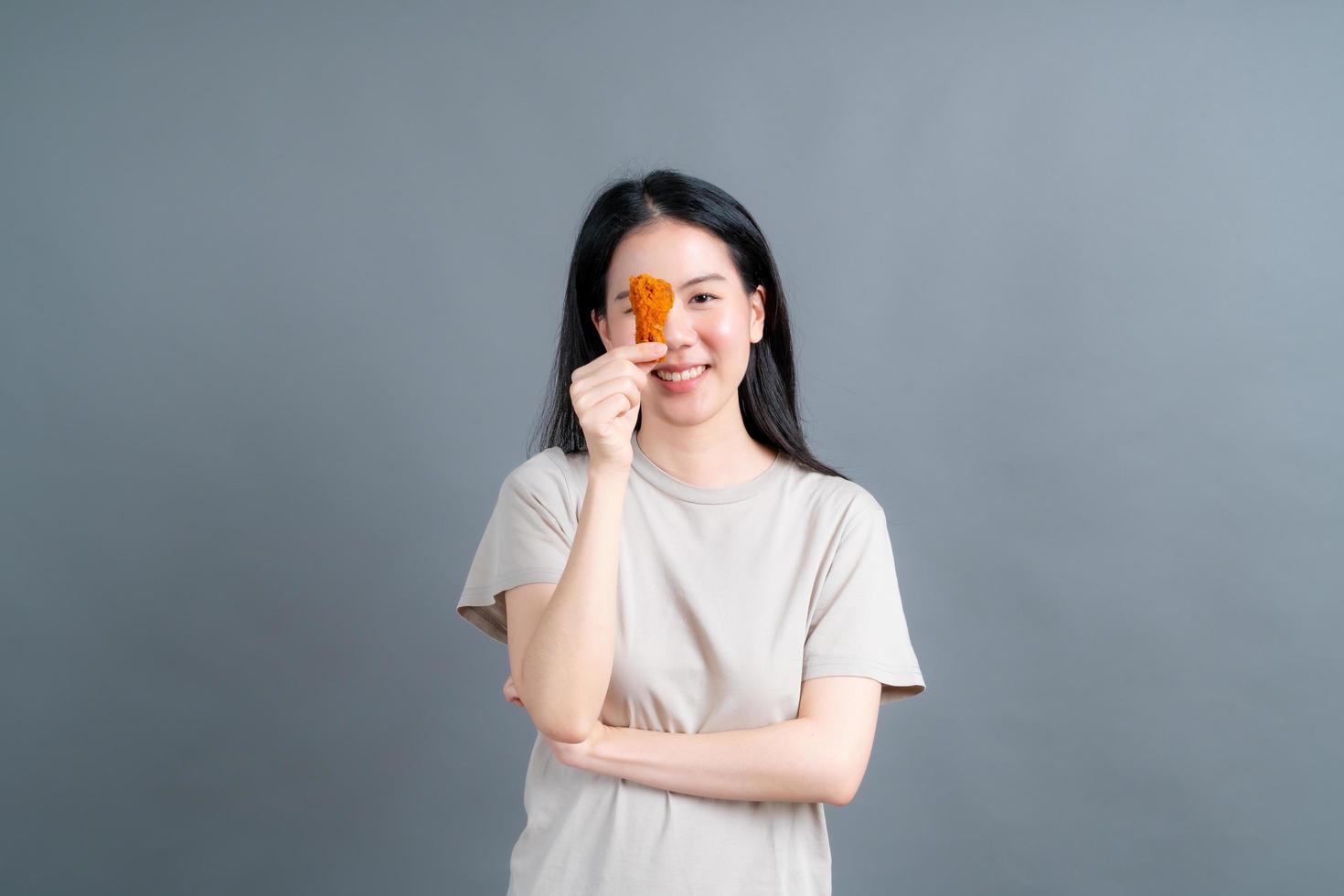 Young Asian woman with happy face and enjoy eating fried chicken photo