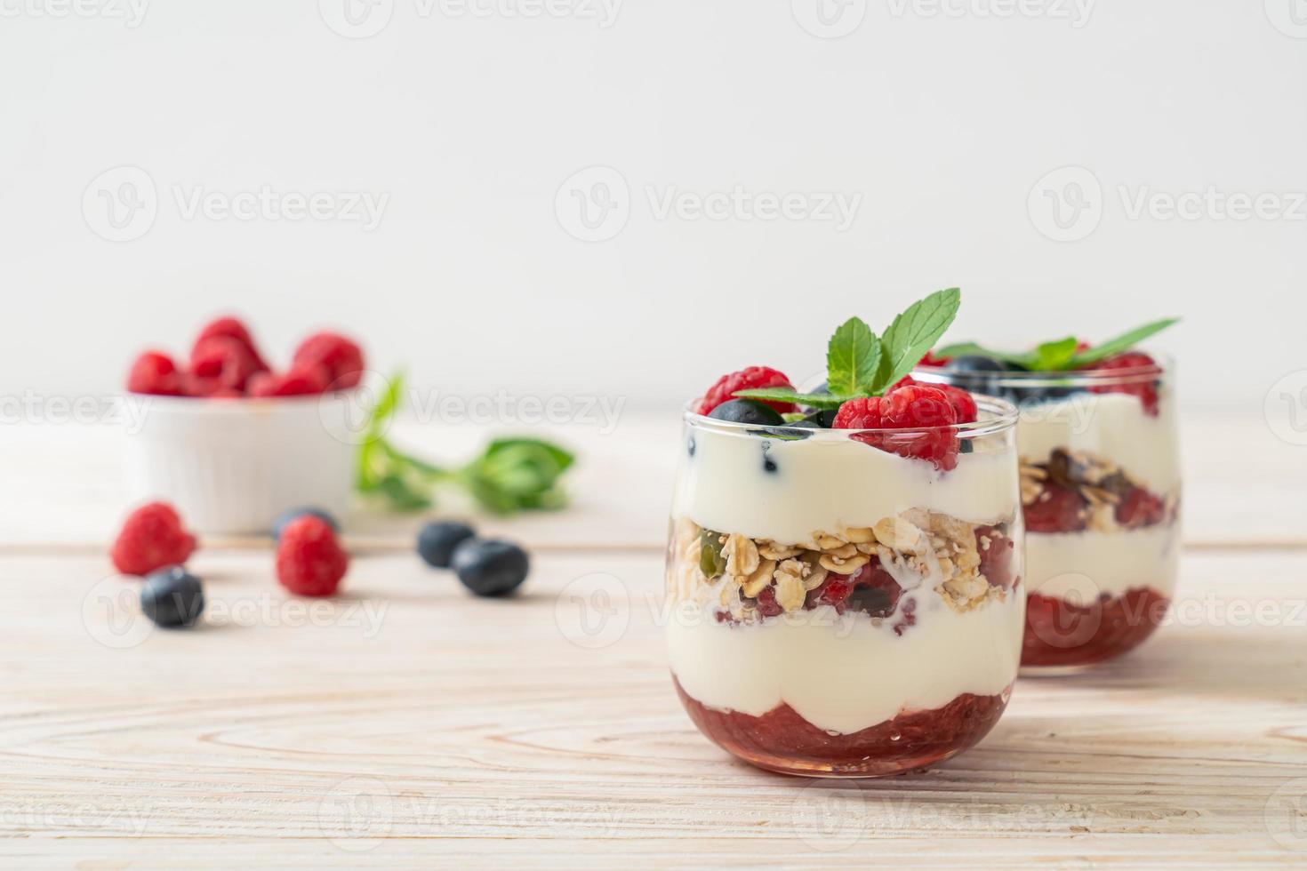 frambuesa y arándano casero con yogur y granola - estilo de comida saludable foto