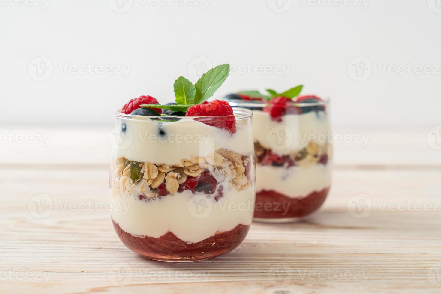 frambuesa y arándano casero con yogur y granola - estilo de comida saludable foto