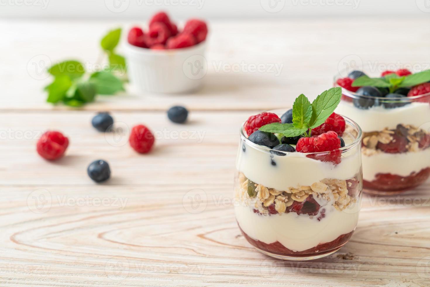 frambuesa y arándano casero con yogur y granola - estilo de comida saludable foto