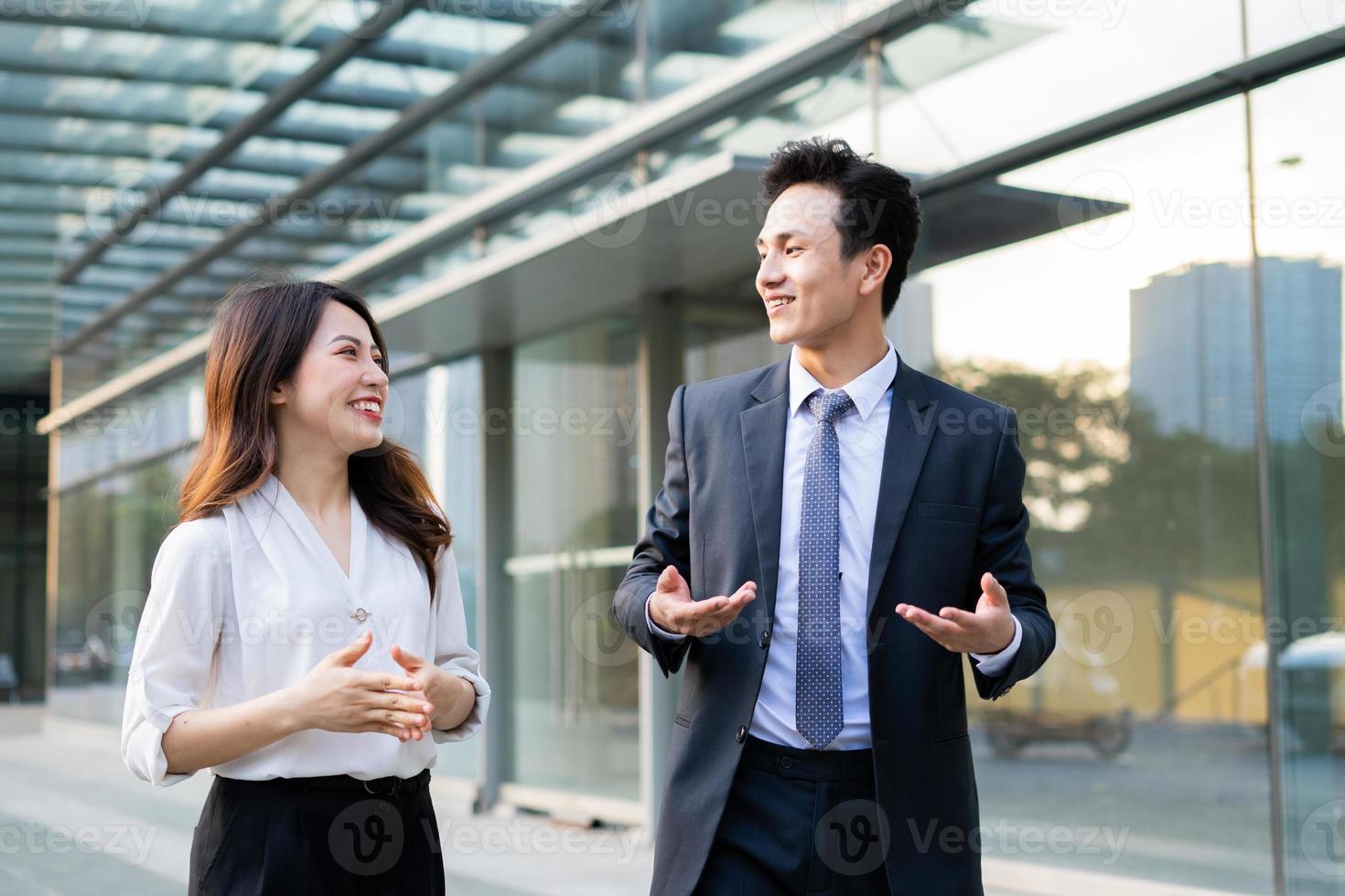 Two business people walking and talking together photo