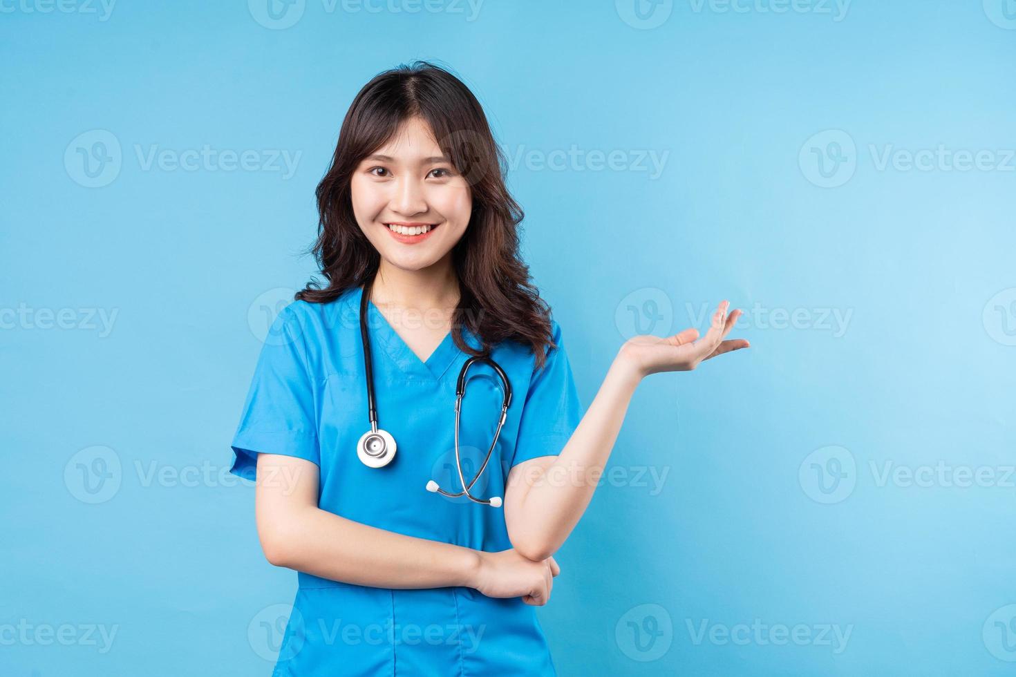 Retrato de joven doctora sonriendo felizmente sobre fondo foto