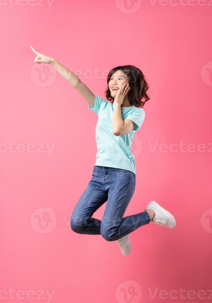 Cheerful young girl jumping up on the background photo