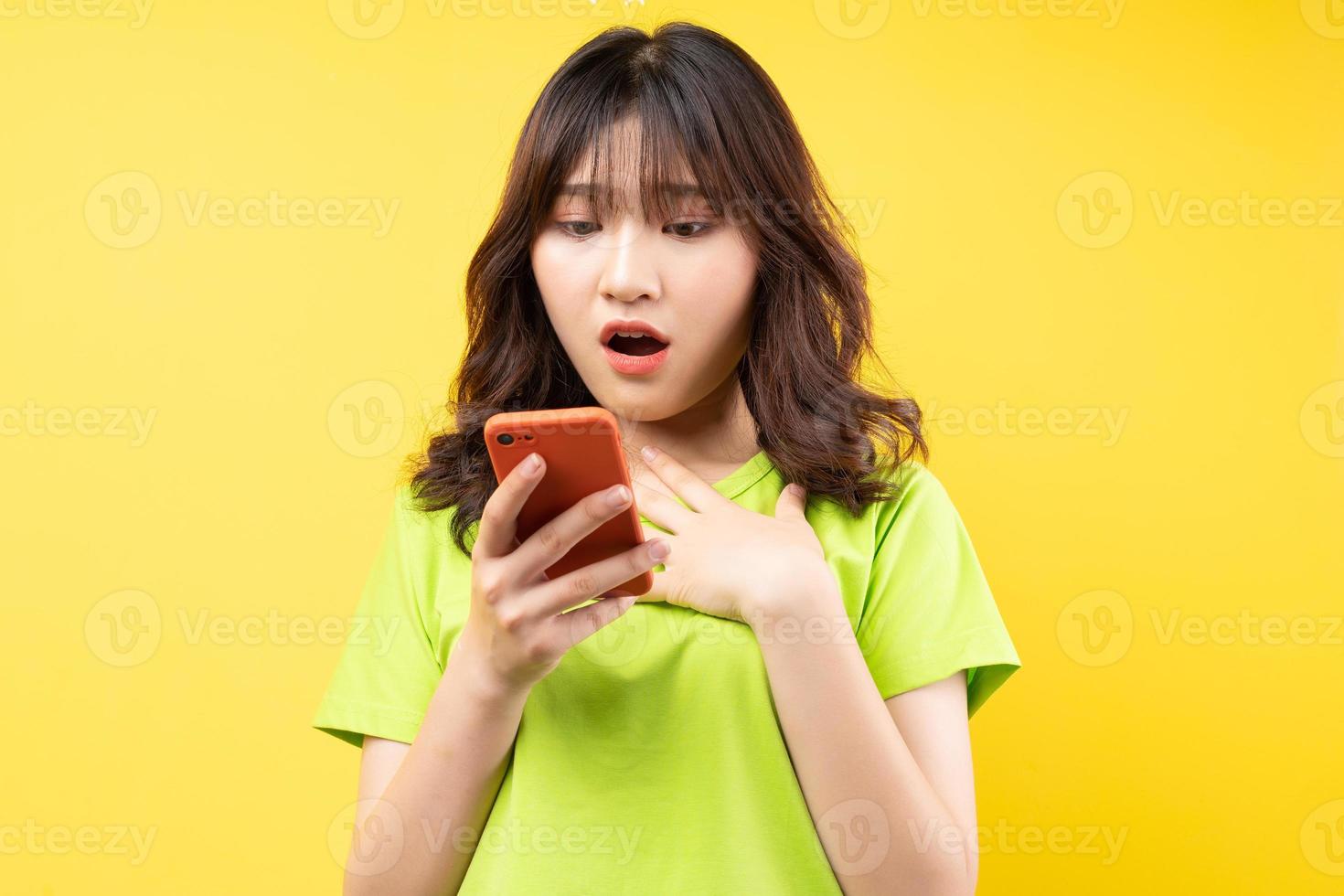 Young girl using phone with surprised expression on background photo