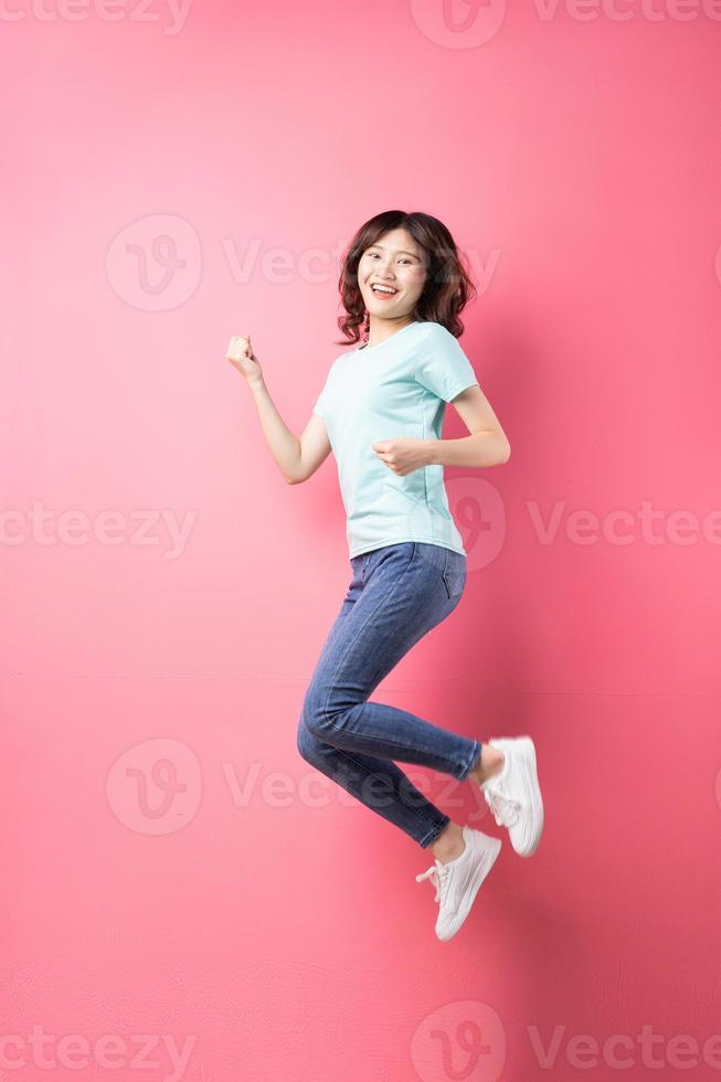 Cheerful young girl jumping up on the background photo