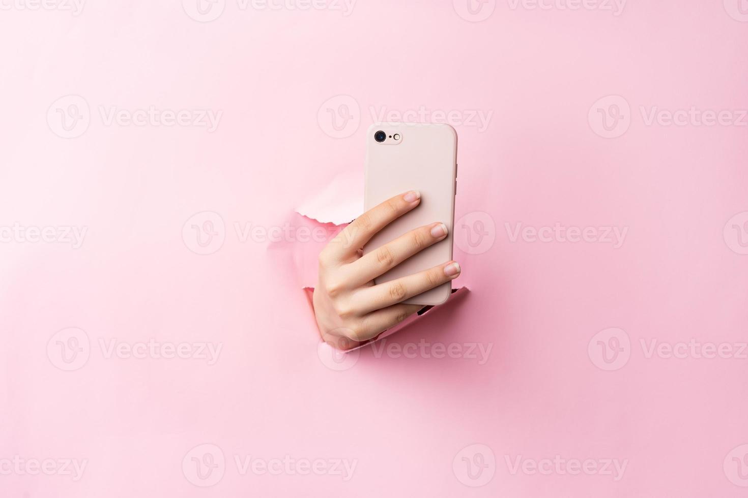 brazo de mujer sosteniendo el teléfono en el fondo foto