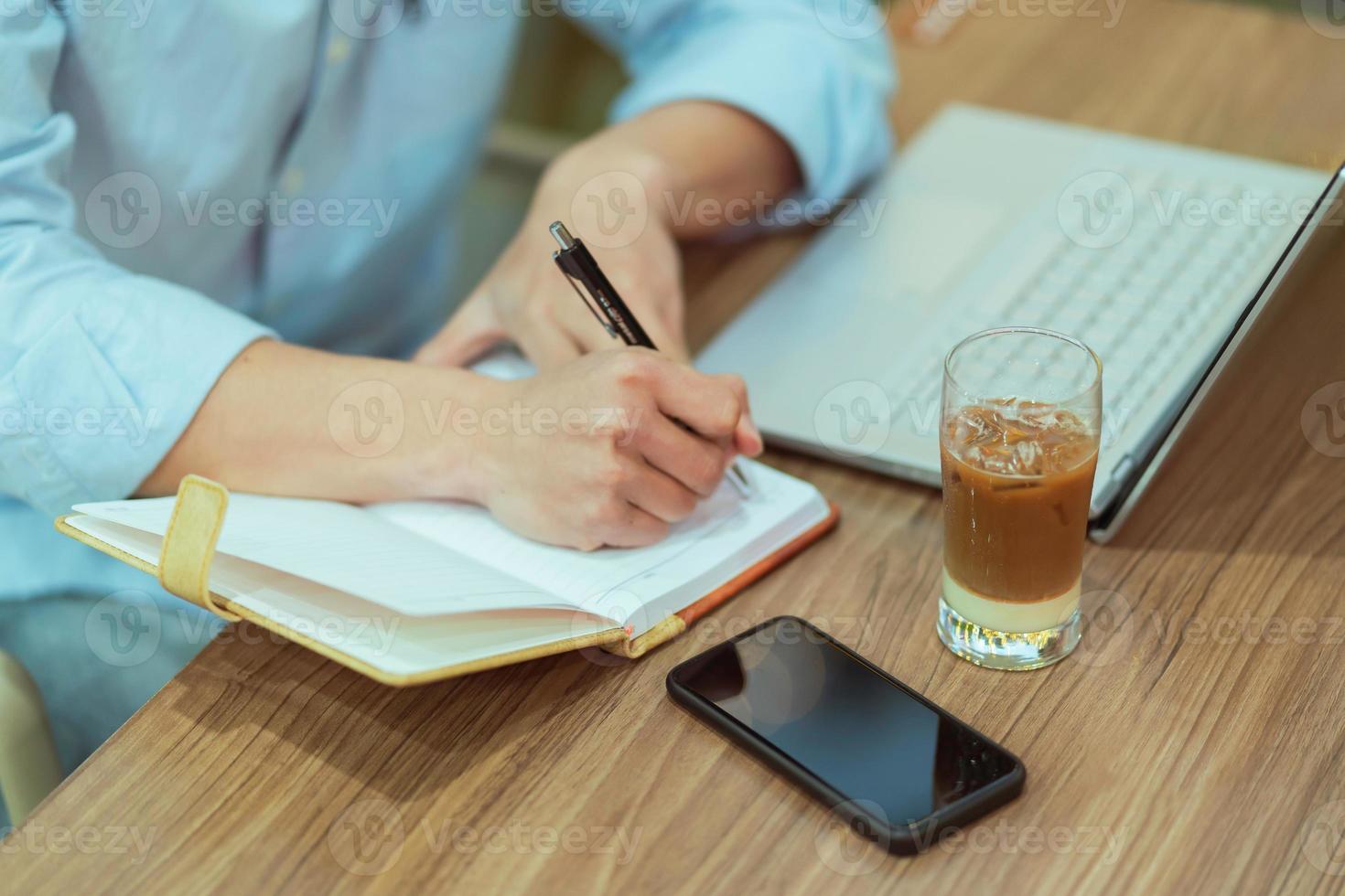 Hombre asiático sentado trabajando solo en una cafetería. foto