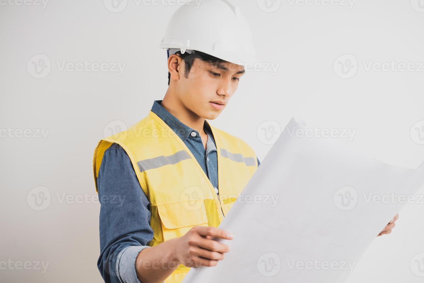 ingeniero de construcción asiático leyendo el dibujo técnico foto