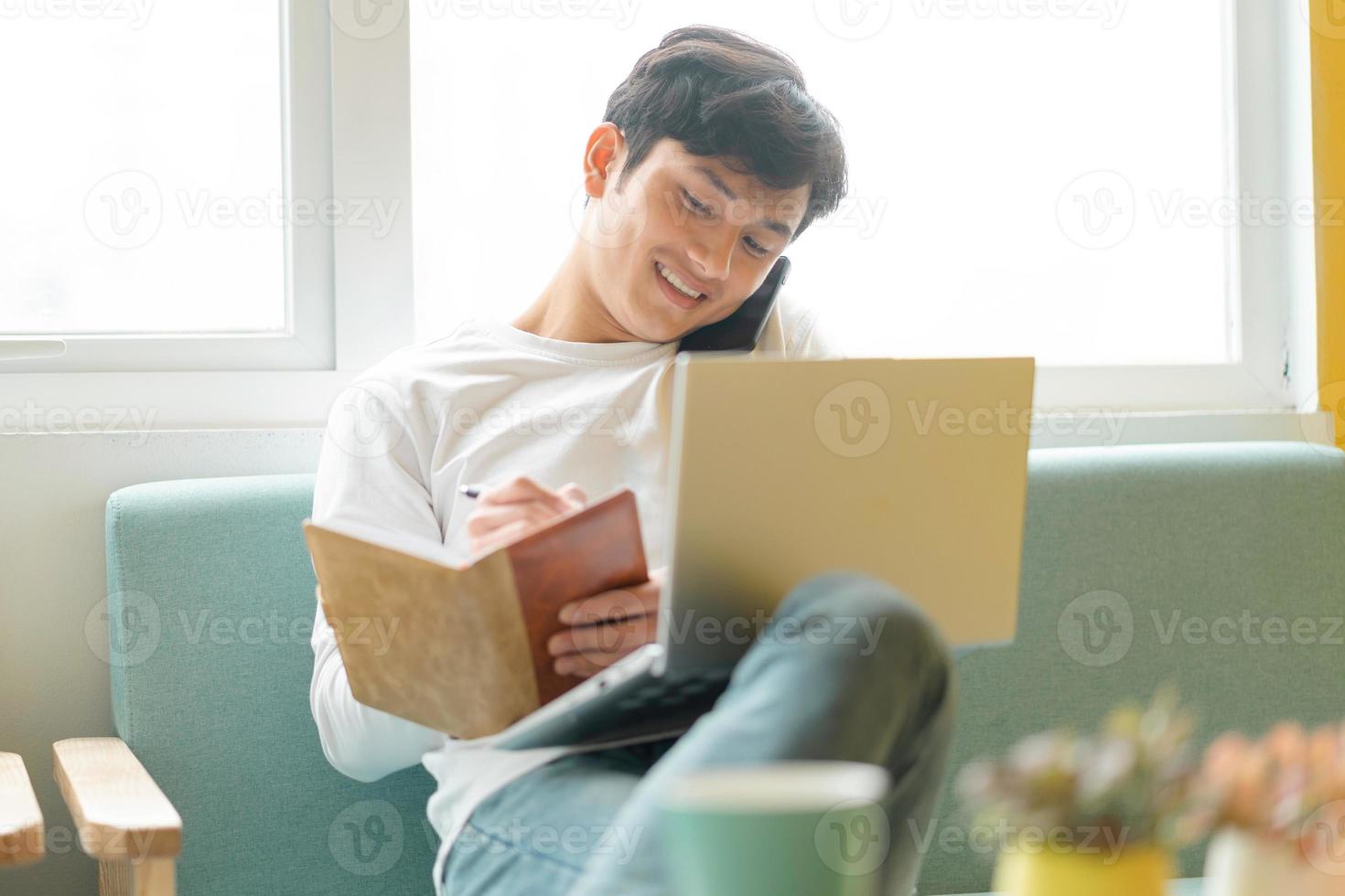 Young Asian man sitting working at home photo