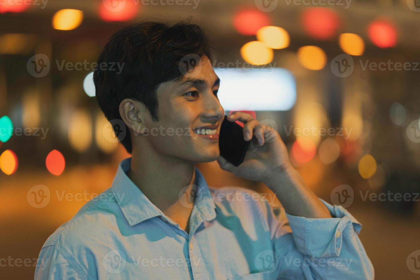 Man is standing using a cell phone in the sky in the evening photo