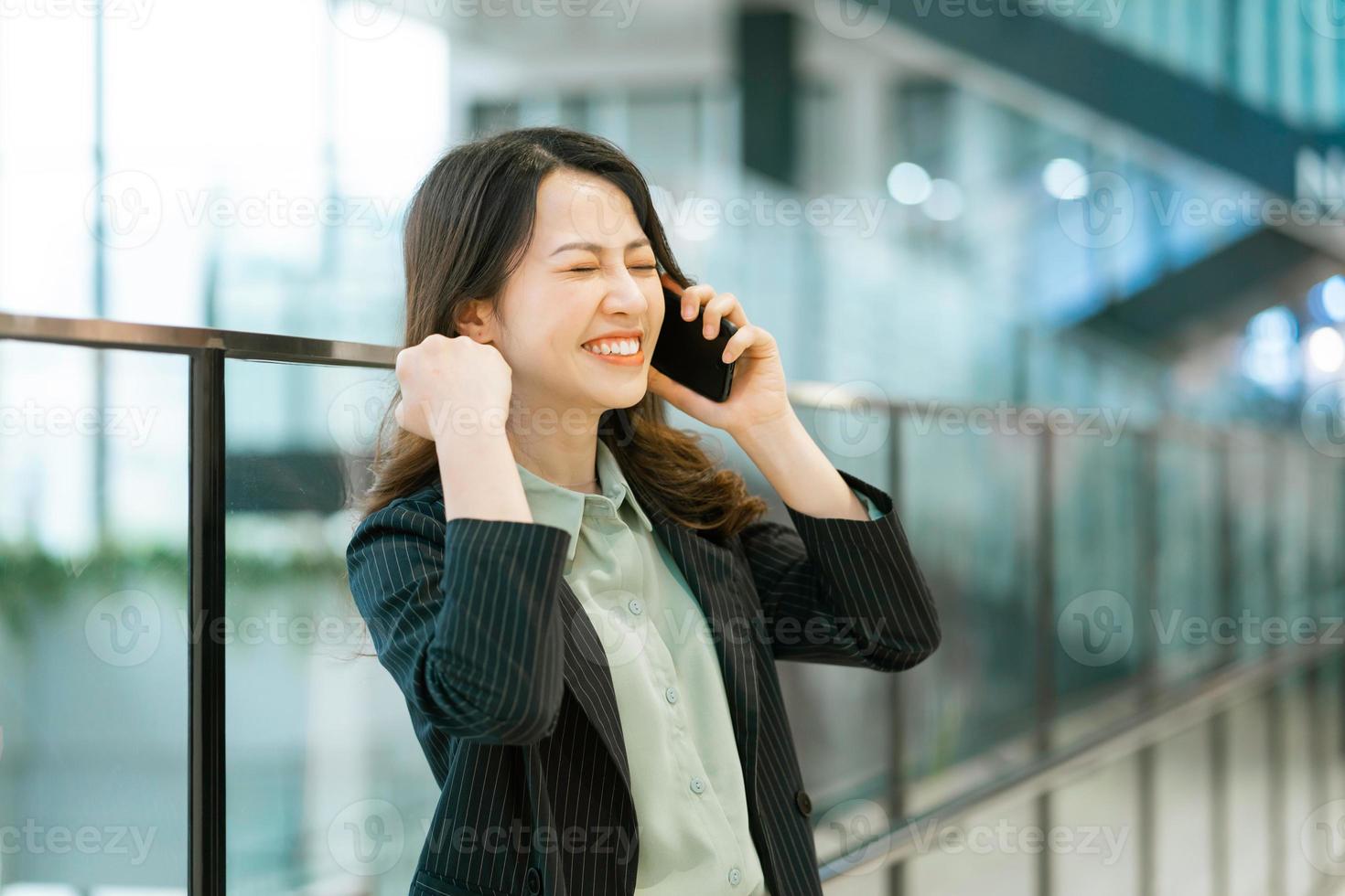 Retrato de una joven directora asiática sosteniendo un teléfono foto