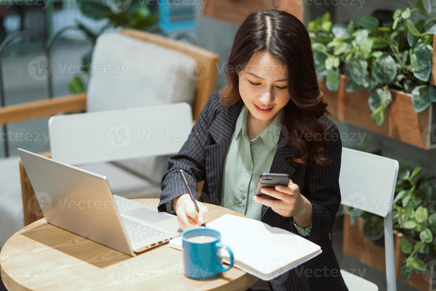 Cheerful young businesswoman working at the coffee shop photo