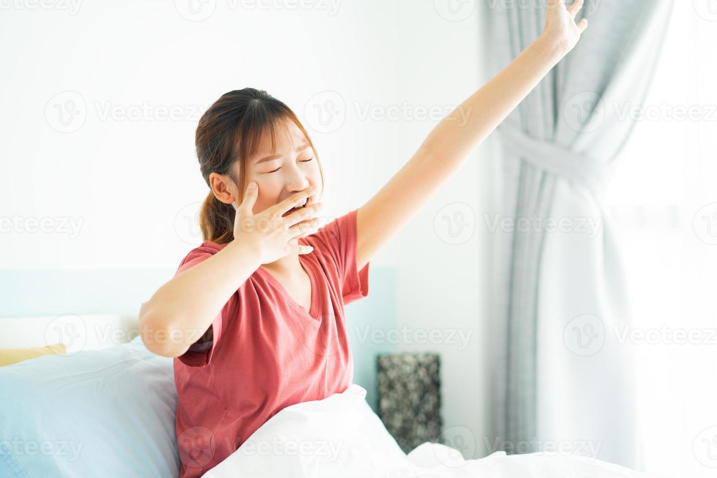 Young Asian woman wake up in early morning photo