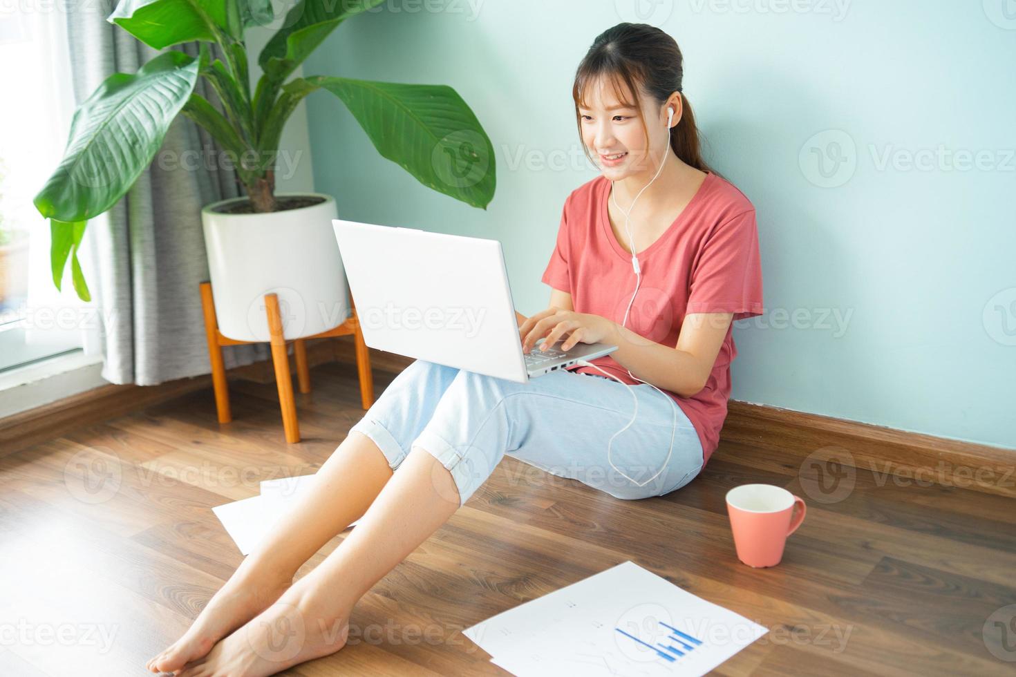 Asian woman sitting on the floor while she working from home photo