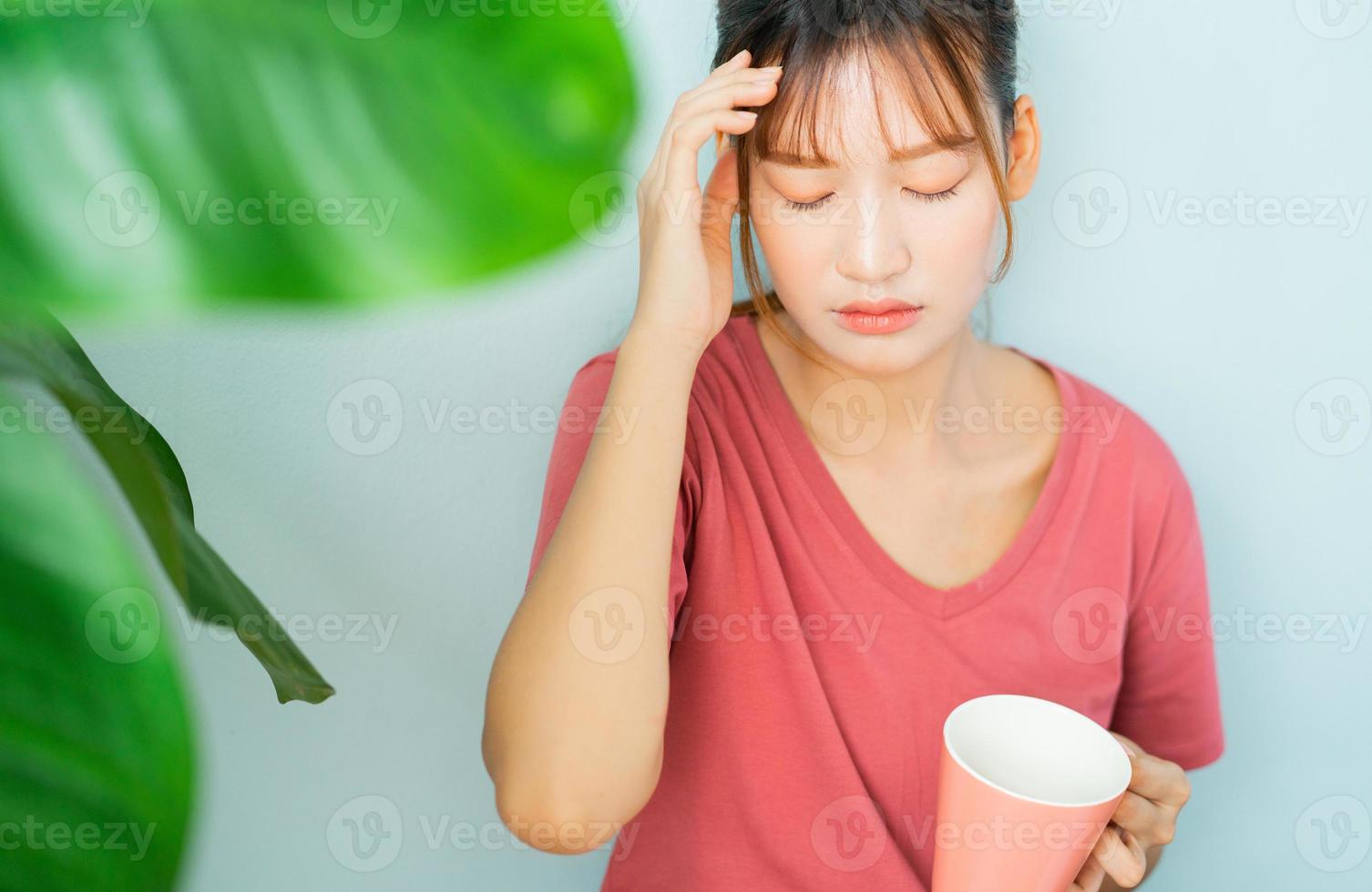 joven mujer asiática bebe café y ella se siente triste foto