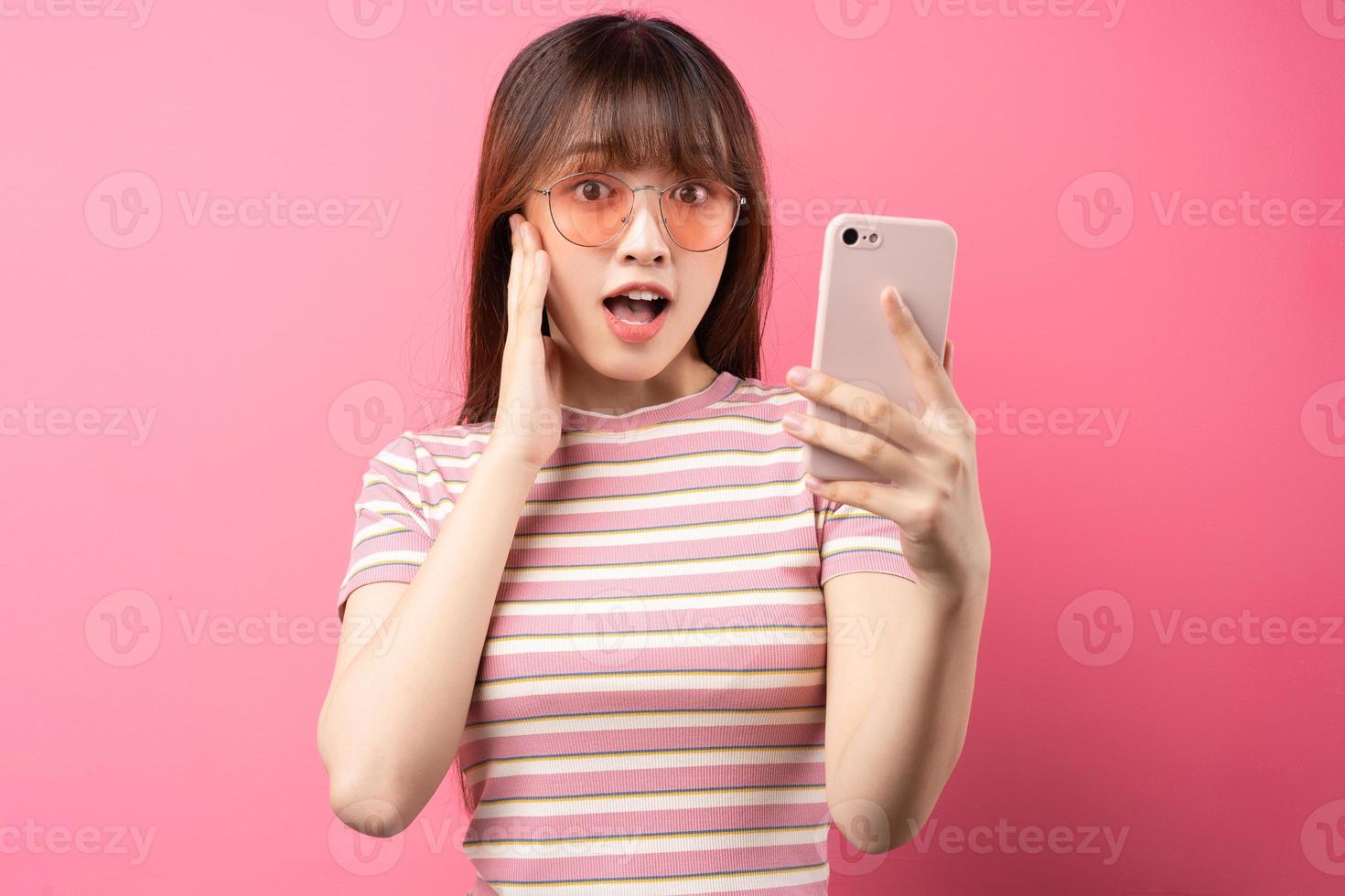 Imagen de una joven asiática con camiseta rosa sobre fondo rosa foto