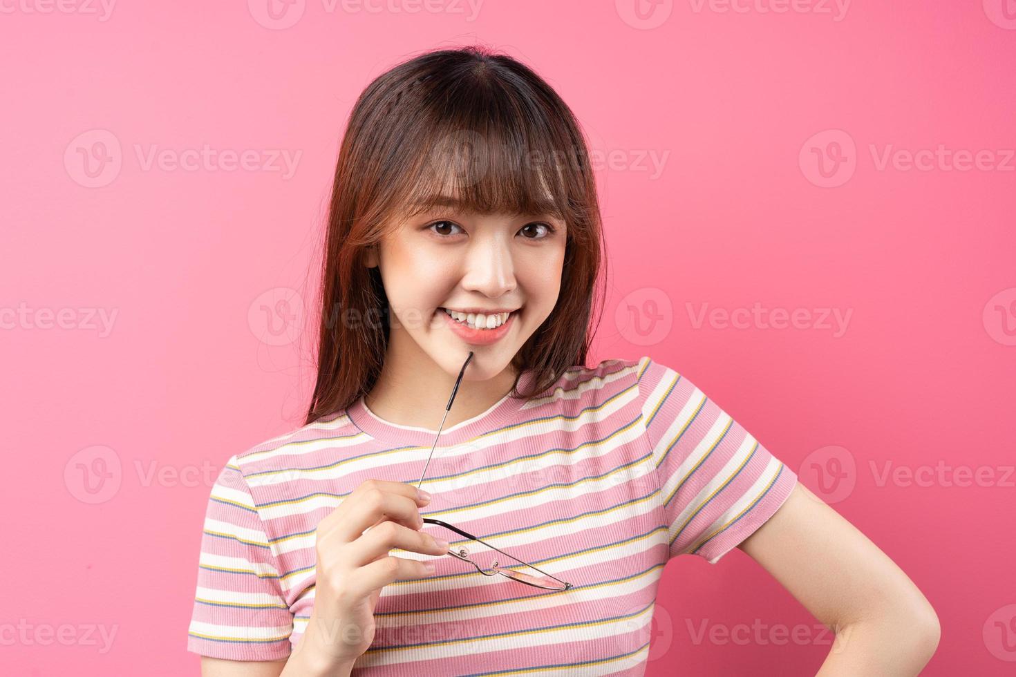 Imagen de una joven asiática con camiseta rosa sobre fondo rosa foto