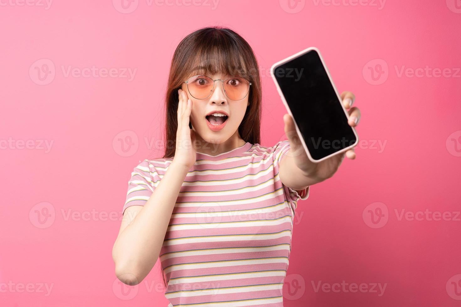 Imagen de una joven asiática con camiseta rosa sobre fondo rosa foto