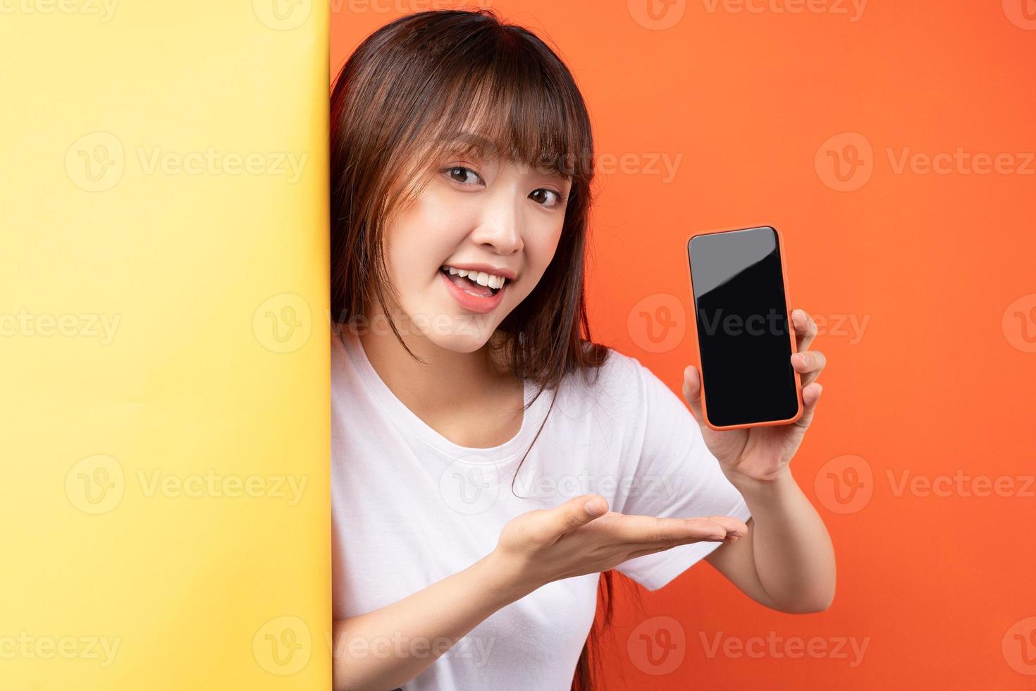 Young Asian girl showing smartphone with empty display photo