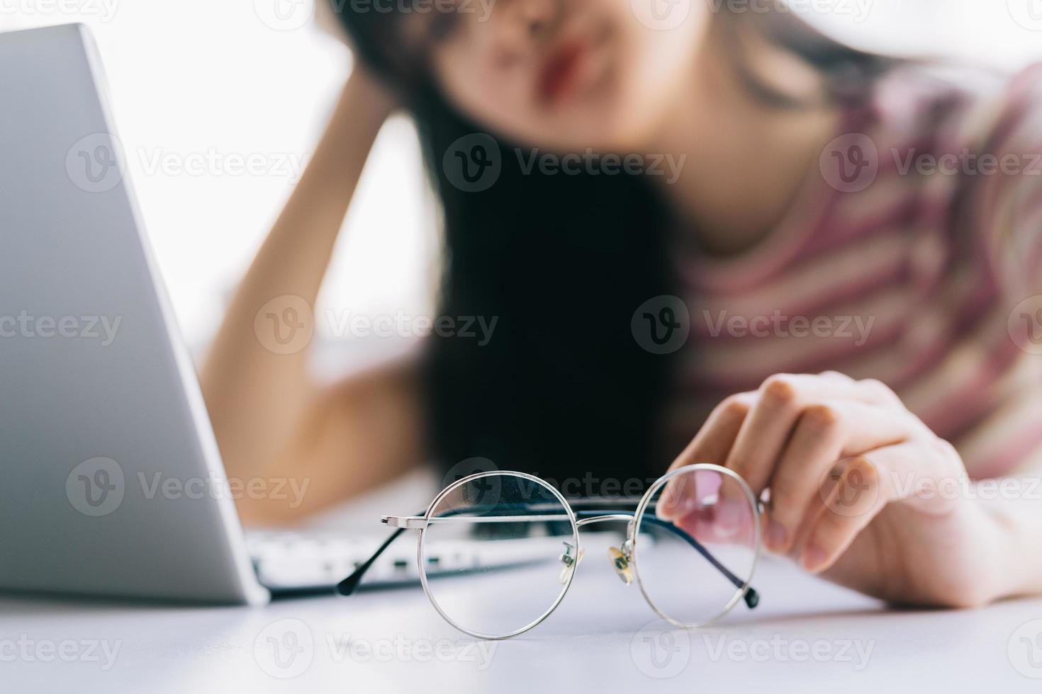 Young Asian girl tired of working long time on computer photo
