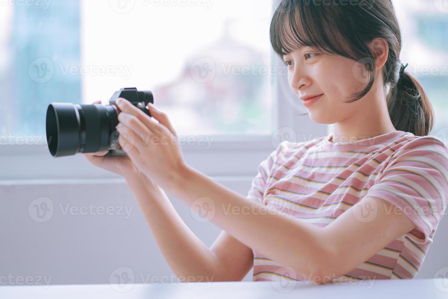 Young Asian woman looking at the newly taken photo on camera