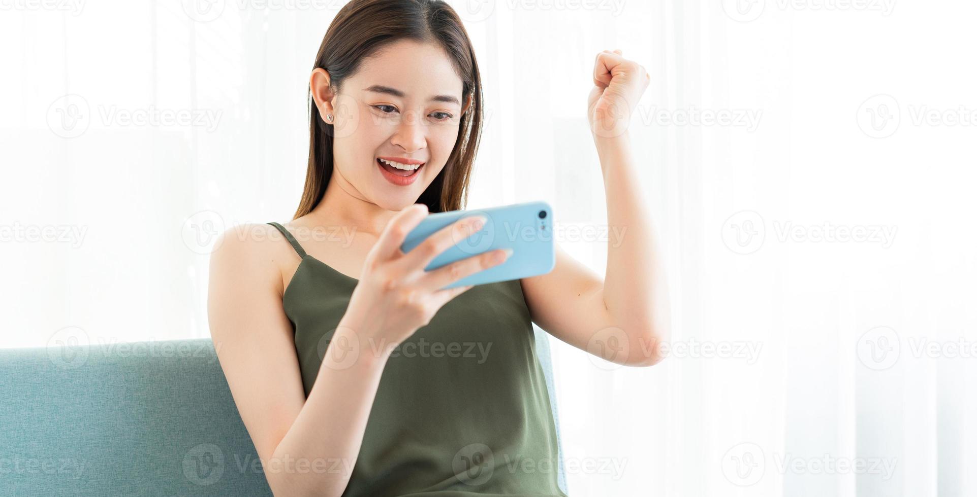 Young Asian woman playing game on phone photo