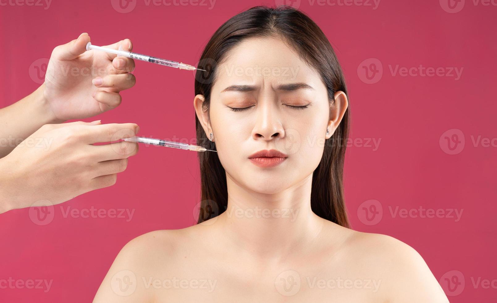 Young Asian woman feeling scared when injecting filler photo