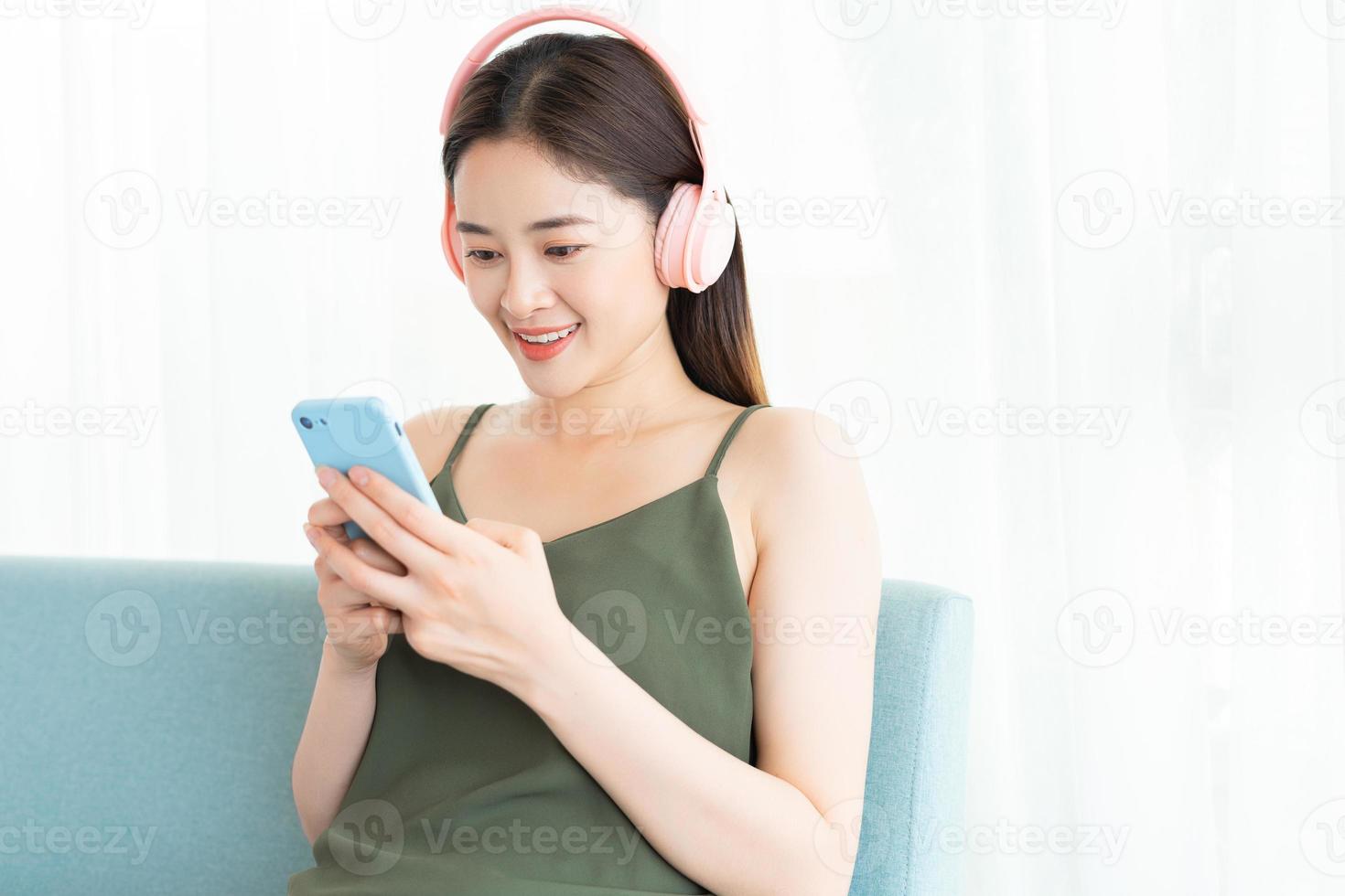 Asian woman is wearing a headset and using the phone photo