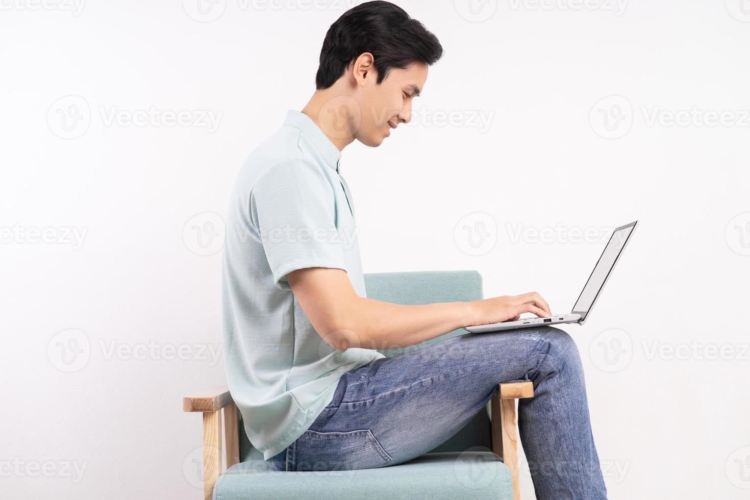 Handsome man with laptop sitting on the working sofa photo