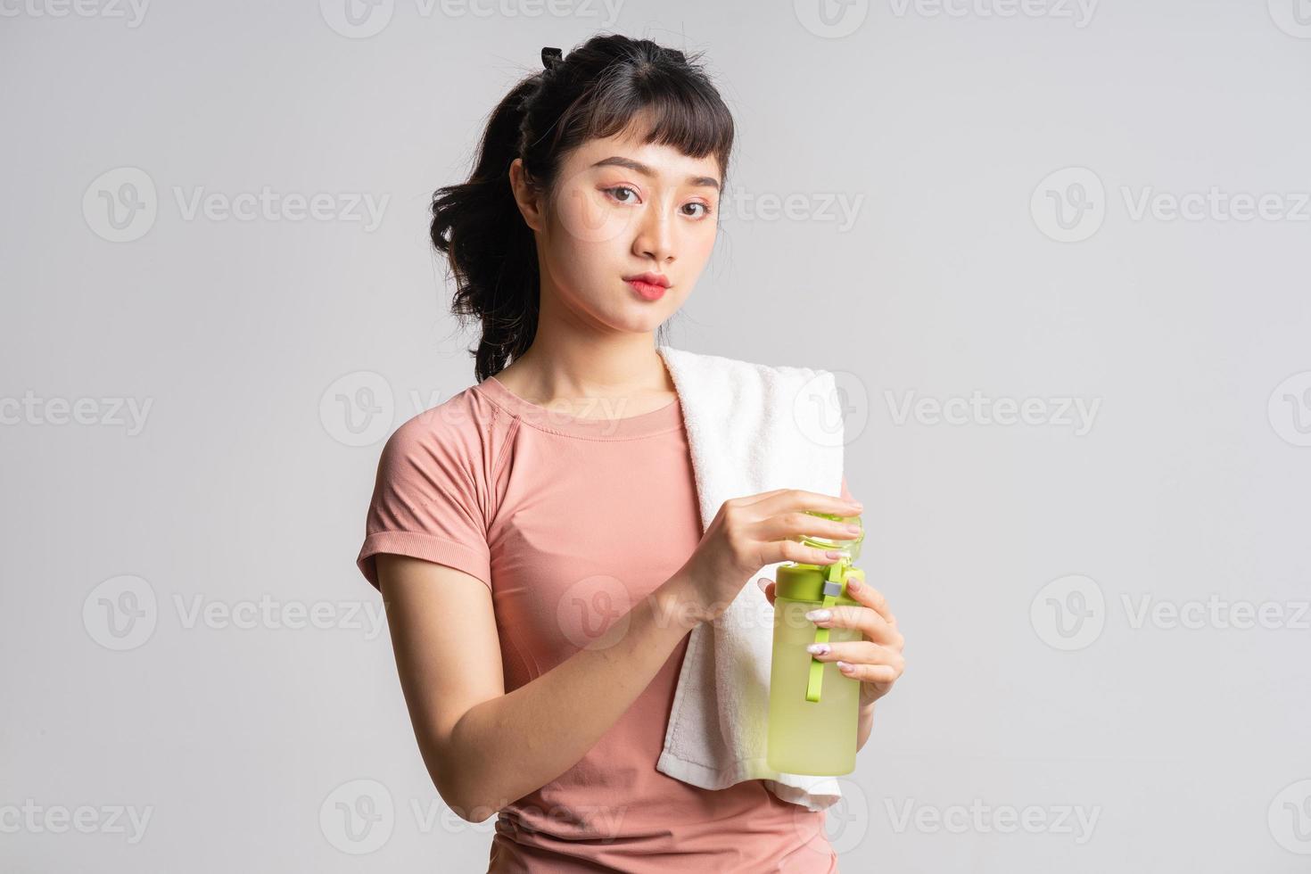 Joven mujer asiática haciendo ejercicio sobre fondo blanco. foto