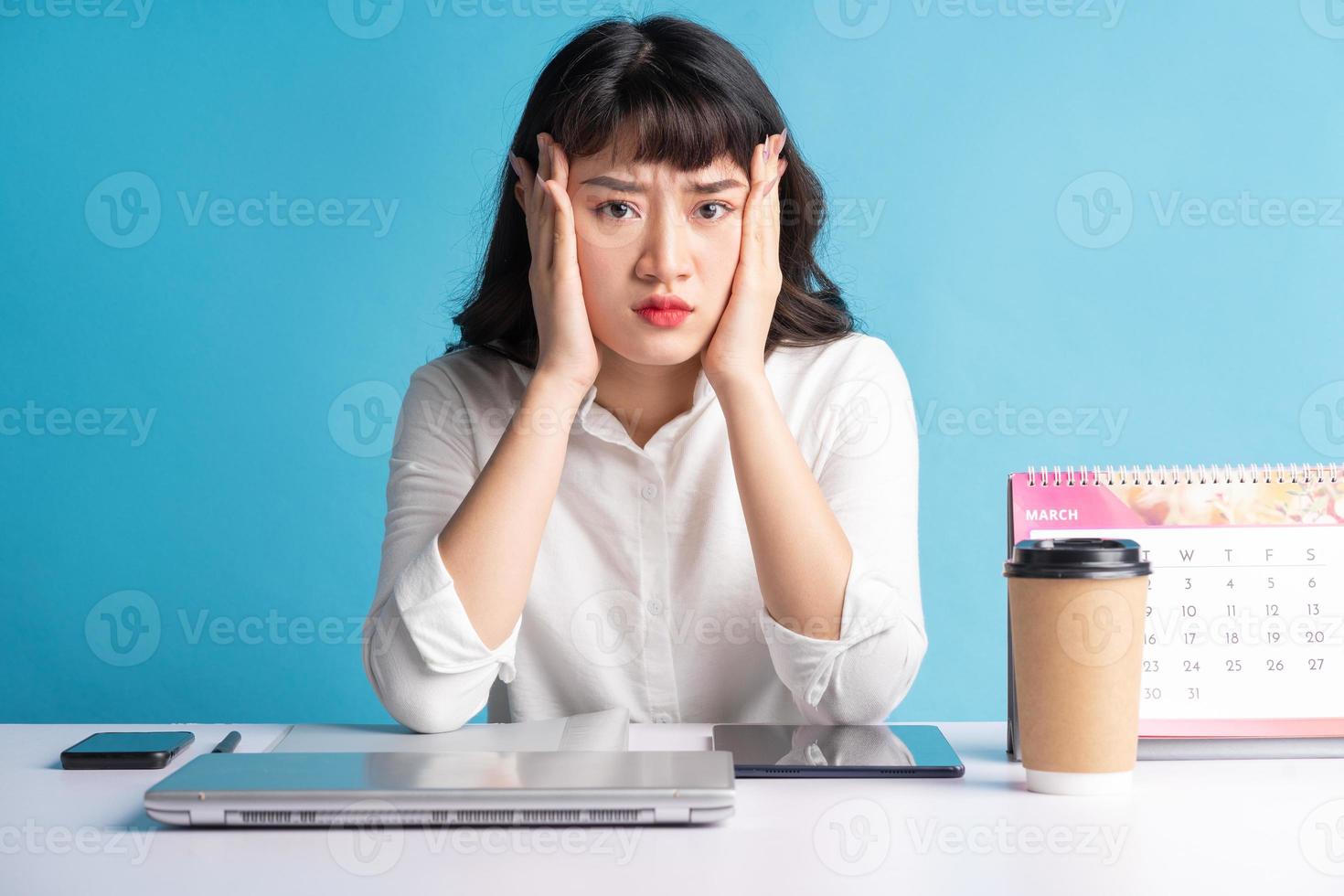 Young Asian buisness woman working on blue background photo