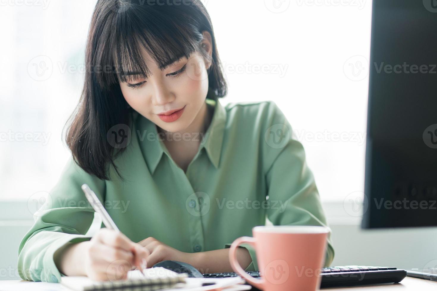 Beautiful Asian businesswoman working intently at the office photo