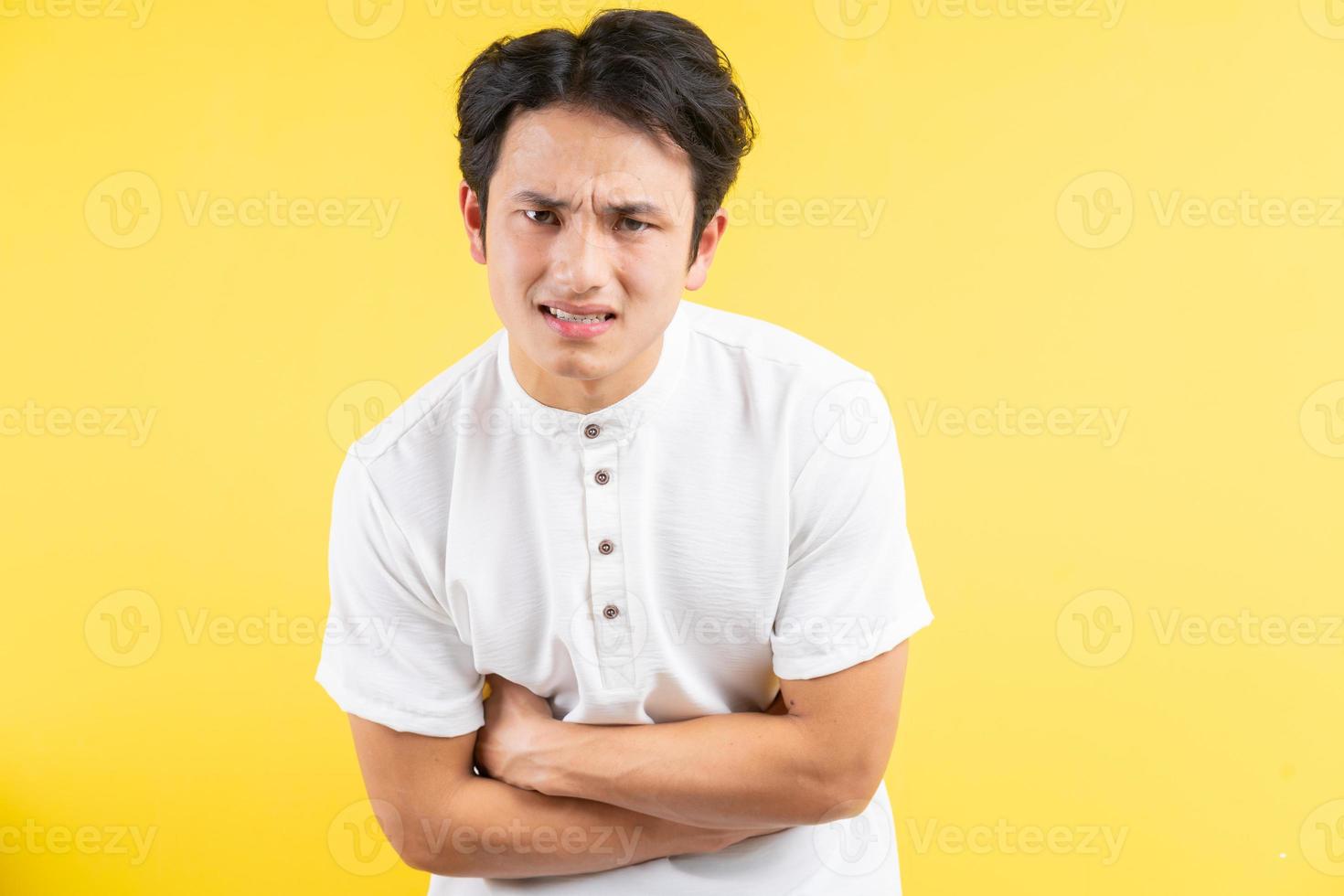 Hombre asiático con dolor de estómago sobre fondo azul. foto